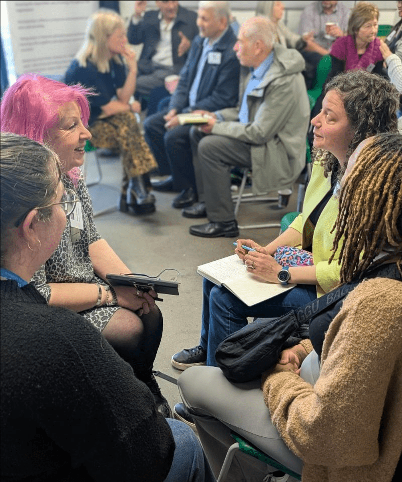 People at a meeting, sitting in a circle, discussing things